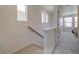 Bright hallway with carpeted stairs and railing leading to the upper level of the house at 10366 Uvalda Ct, Commerce City, CO 80022