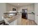 Light-filled kitchen boasts granite countertops, stainless steel appliances, a large sink, and stylish, shaker style cabinets at 10366 Uvalda Ct, Commerce City, CO 80022