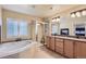 Luxurious bathroom with soaking tub, walk-in shower, dual sink vanity, and fireplace at 23029 Cleveland Dr, Parker, CO 80138