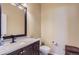 Powder room featuring dark vanity, modern fixtures, toilet, and neutral wall color at 23029 Cleveland Dr, Parker, CO 80138
