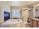 Bathroom features soaking tub, walk-in shower, tile surround, and large window for natural light at 23029 Cleveland Dr, Parker, CO 80138