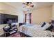 Relaxing bedroom boasts a ceiling fan, sleek TV setup, and modern decor at 23029 Cleveland Dr, Parker, CO 80138