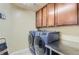 Spacious laundry room features modern washer and dryer and ample cabinet space at 23029 Cleveland Dr, Parker, CO 80138