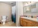 Cozy bathroom featuring a shower with a curtain, light wood vanity, and neutral tiling at 7522 S Mount Zirkel, Littleton, CO 80127