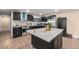 Modern kitchen with stainless steel appliances, dark cabinets, and a large island at 7522 S Mount Zirkel, Littleton, CO 80127