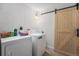 Laundry room with modern washer and dryer, light wood sliding door, and storage space at 7522 S Mount Zirkel, Littleton, CO 80127