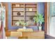 Dining room with a built-in bookshelf, dark blue walls, and a view through an adjacent window at 2236 Forest St, Denver, CO 80207
