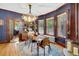 Elegant dining room featuring hardwood floors, a modern chandelier, dark blue walls, and large windows for ample natural light at 2236 Forest St, Denver, CO 80207