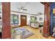 Inviting living room showcases original hardwood floors, ceiling fans, and comfortable seating with large windows and an area rug at 2236 Forest St, Denver, CO 80207