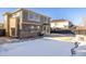 Large backyard with concrete patio, brick home exterior, and snowy landscape at 3012 S Jericho Way, Aurora, CO 80013