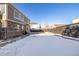 Spacious backyard with a view of the home's exterior and a snow-covered lawn at 3012 S Jericho Way, Aurora, CO 80013