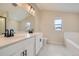 Modern bathroom featuring double sinks, a large mirror, and a separate tub and shower at 6906 Kendrick Ln, Arvada, CO 80007