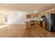 Open-concept kitchen with stainless steel appliances, light wood cabinets, white countertops, and hardwood flooring at 1411 S Welch Cir, Lakewood, CO 80228