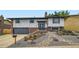 Inviting home exterior featuring manicured rock garden, modern front door, and attached garage at 2176 S Welch Cir, Lakewood, CO 80228
