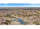 Expansive aerial view of a neighborhood with a serene pond, lush trees, and a distant city skyline at 671 Hiddenbrook Ct, Littleton, CO 80126