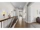 Bright hallway showcasing hardwood floors, decorative lighting, and elegant iron railing at 671 Hiddenbrook Ct, Littleton, CO 80126