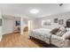 Finished basement with wood flooring, a bed, and access to an adjacent room at 2757 E Geddes Ave, Centennial, CO 80122