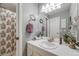 Well-lit bathroom featuring a vanity, mirror, and shower with decorative shower curtain at 2757 E Geddes Ave, Centennial, CO 80122