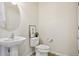 Half bathroom with round mirror, pedestal sink and decorative print at 17032 Blue Mist Grv, Monument, CO 80132