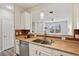 Kitchen sink with stainless steel appliances, white cabinets, and tile backsplash at 17032 Blue Mist Grv, Monument, CO 80132