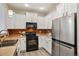 Modern kitchen featuring white cabinets, stainless steel appliances, and stylish tile backsplash at 17032 Blue Mist Grv, Monument, CO 80132