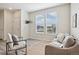 Cozy living room features two large windows, modern furnishings, and wood flooring at 17032 Blue Mist Grv, Monument, CO 80132