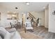 Open-concept living space with a staircase, dining area, and view into the modern kitchen at 17032 Blue Mist Grv, Monument, CO 80132