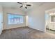 Spacious carpeted bedroom with large windows and ceiling fan at 303 Tumbleweed Dr, Brighton, CO 80601