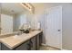 Bathroom featuring a double vanity, a large mirror, and bright lighting with doors on either side at 254 Ellendale St, Castle Rock, CO 80104