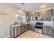 Bright kitchen with stainless appliances, gray cabinets, granite countertops, and tile floors at 254 Ellendale St, Castle Rock, CO 80104