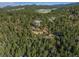Expansive aerial view of secluded mountain estate surrounded by lush green forest landscape at 5699 Northwood Dr, Evergreen, CO 80439