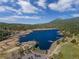 Breathtaking aerial view of the property, showcasing the lake, golf course, and surrounding landscape at 5699 Northwood Dr, Evergreen, CO 80439