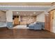 Spacious basement with built-in shelves, a gray couch, and wood-look flooring at 5699 Northwood Dr, Evergreen, CO 80439