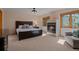 Bedroom with fireplace, large bed, neutral colors and comfortable seating at 5699 Northwood Dr, Evergreen, CO 80439