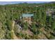Secluded mountain home with a green roof nestled among tall pines and native landscaping at 5699 Northwood Dr, Evergreen, CO 80439