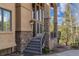 Inviting front entrance with stone accents, elegant lighting, and a well-maintained walkway at 5699 Northwood Dr, Evergreen, CO 80439
