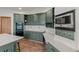 Charming kitchen with green cabinetry, modern appliances, and sleek countertops at 5699 Northwood Dr, Evergreen, CO 80439