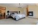 A cozy main bedroom featuring a fireplace, soft lighting, and a king-size bed at 5699 Northwood Dr, Evergreen, CO 80439