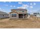 Rear exterior of a two-story home with a covered patio and a spacious, unfinished backyard at 574 Penn Rd, Elizabeth, CO 80107