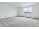 Carpeted bedroom featuring a bright window with a view of the neighborhood at 574 Penn Rd, Elizabeth, CO 80107