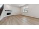 Bright living room featuring light wood floors, fireplace, and large window at 574 Penn Rd, Elizabeth, CO 80107
