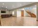 A sprawling basement with laminate flooring, media area, and winding staircase at 634 County Road 37, Brighton, CO 80603