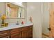 Bathroom with wood cabinets, stone countertop, and sink, with a view of a doorway and mirror at 634 County Road 37, Brighton, CO 80603
