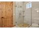 Bathroom with a glass door shower with white tiling, a window, and a stone-tiled floor at 634 County Road 37, Brighton, CO 80603