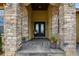 Close-up of the front door, showcasing the stone pillars and manicured flower pots at 634 County Road 37, Brighton, CO 80603