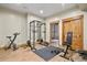 Basement home gym with laminate flooring and fitness equipment including squat rack and stationary bike at 634 County Road 37, Brighton, CO 80603
