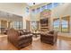 Spacious living room with hardwood floors, stone fireplace, and large windows at 634 County Road 37, Brighton, CO 80603
