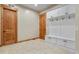 Mudroom has white cabinets with bench and coat hooks, tile flooring, and wooden doors and trim at 634 County Road 37, Brighton, CO 80603