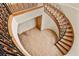 Aerial view of a curved wood staircase with black metal handrail and laminate flooring at 634 County Road 37, Brighton, CO 80603