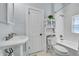 Bright bathroom with white tile, updated fixtures, and a stylish pedestal sink at 1208 S Pennsylvania St, Denver, CO 80210